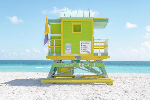 a lifeguard tower on the beach with a flag on it