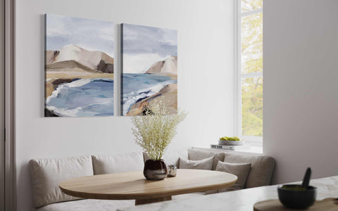 a living room with a table and two paintings on the wall