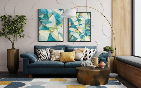 a living room with a blue couch and two paintings on the wall