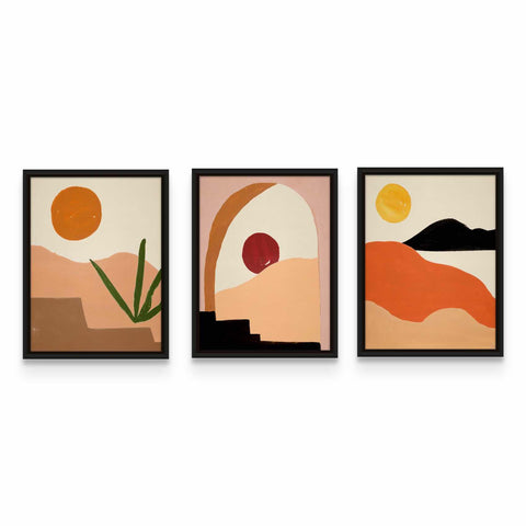 three framed paintings of desert scenes on a white wall