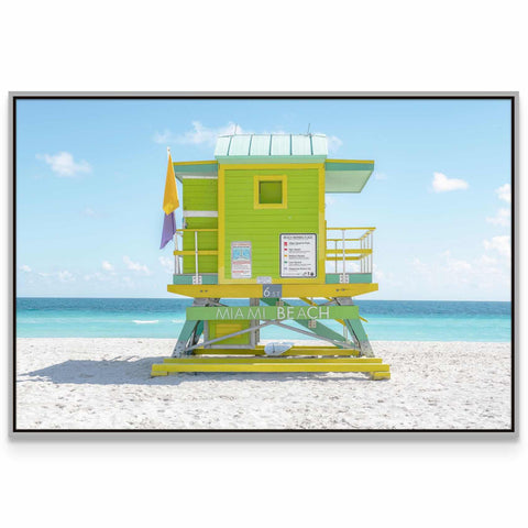 a lifeguard tower on the beach with a blue sky in the background