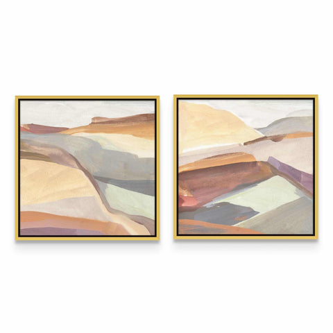 two framed paintings of mountains on a white wall