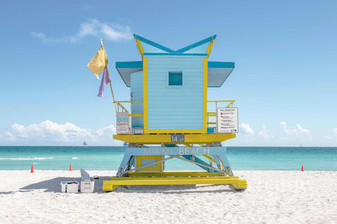 a yellow and blue lifeguard tower on a beach