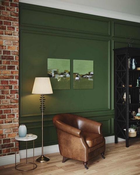 a living room with green walls and a leather chair