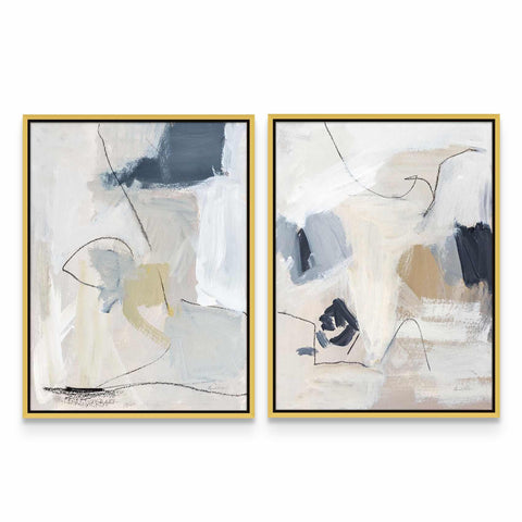 two abstract paintings in gold frames on a white wall