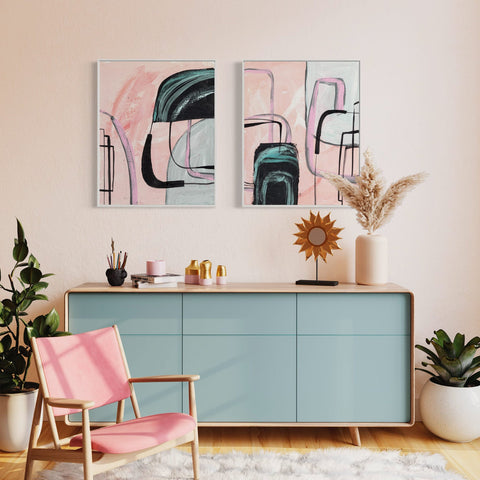 a room with two paintings on the wall and a pink chair