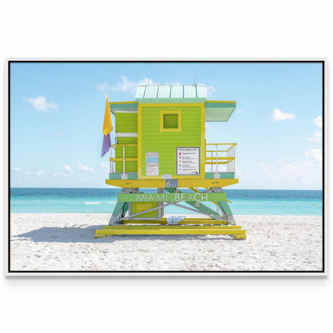 a lifeguard tower on the beach with a blue sky in the background