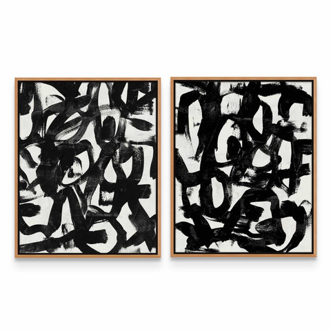 two black and white paintings on a wall