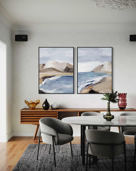 a dining room with two paintings on the wall