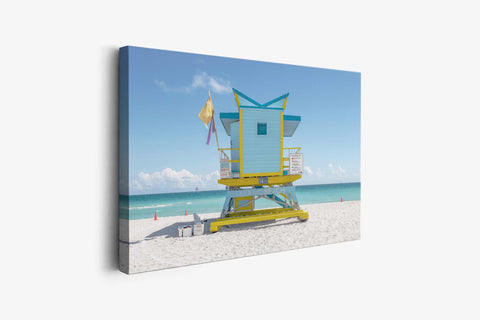 a lifeguard tower on the beach with a blue sky in the background