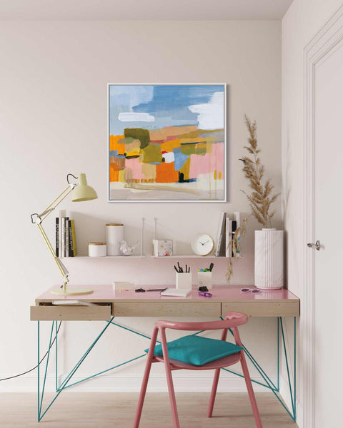 a desk with a chair and a painting on the wall