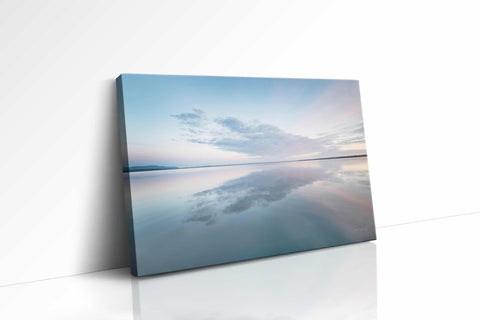 a canvas mounted on a wall with a reflection of the sky in the water