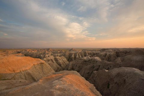 the sun is setting over the badlands of the badlands