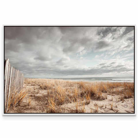 a picture of a beach with grass and a fence