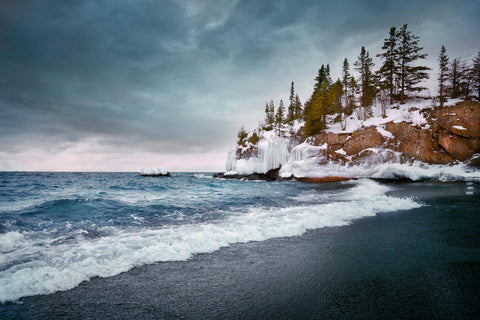 a large body of water next to a rocky shore