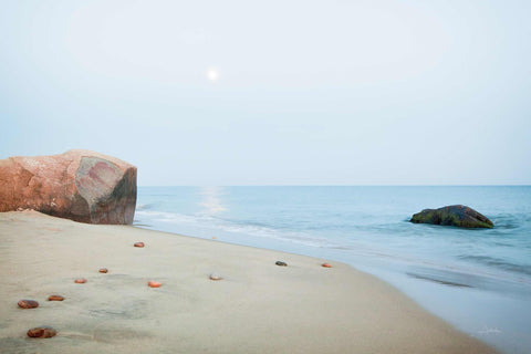 a large rock sitting on top of a sandy beach