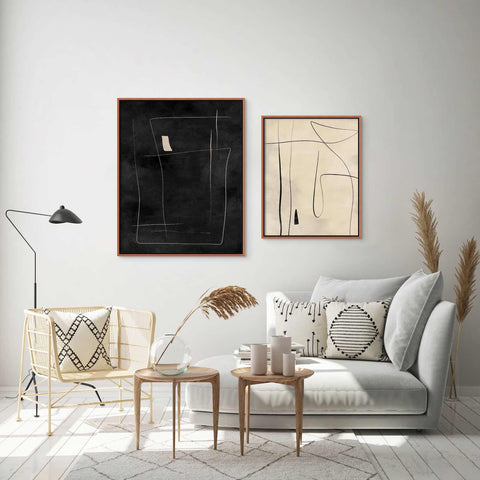 a living room with a white couch and two paintings on the wall