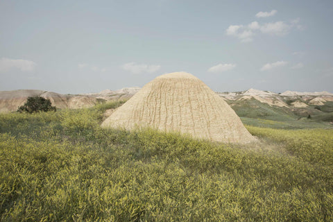 a large mound of sand sitting in a field