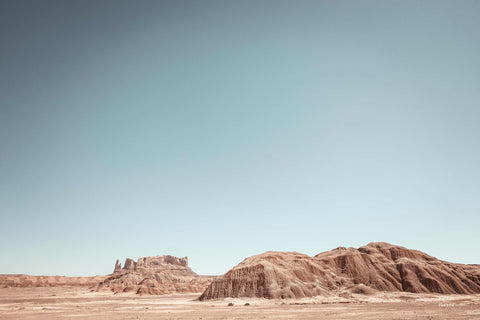 a desert landscape with mountains and a blue sky