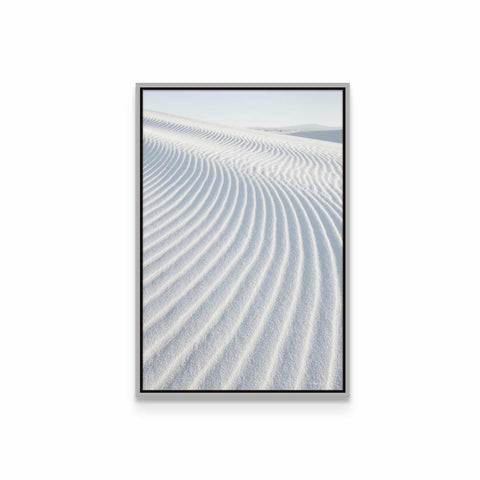 a framed photograph of a white sand dune