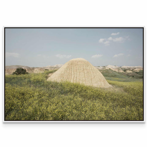 a large mound of sand in a grassy field