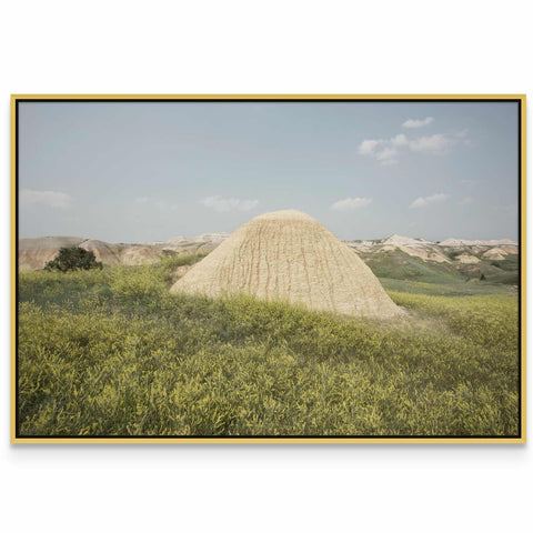 a large mound of sand in a grassy field