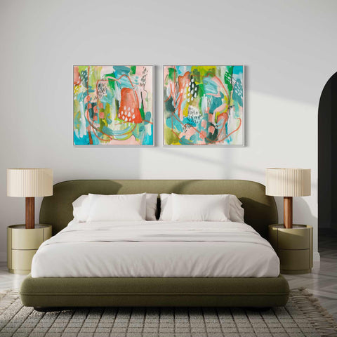 a bedroom with a bed and two paintings on the wall