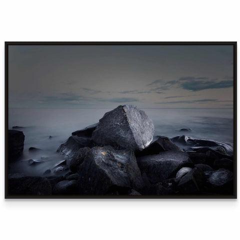 a black and white photo of rocks and water