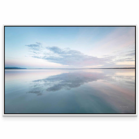 a large body of water with a sky in the background