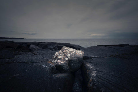 a large rock sitting on top of a rocky beach