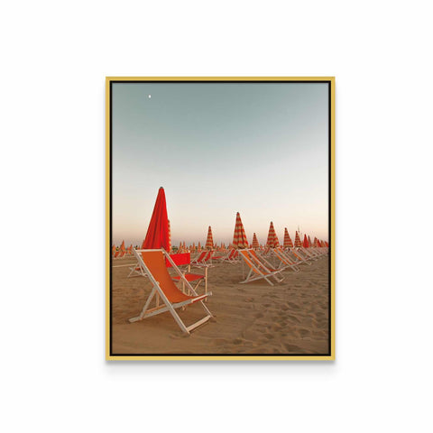 a row of lawn chairs sitting on top of a sandy beach