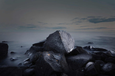 a large rock sitting on top of a rocky beach