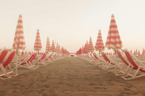 a row of beach chairs sitting on top of a sandy beach