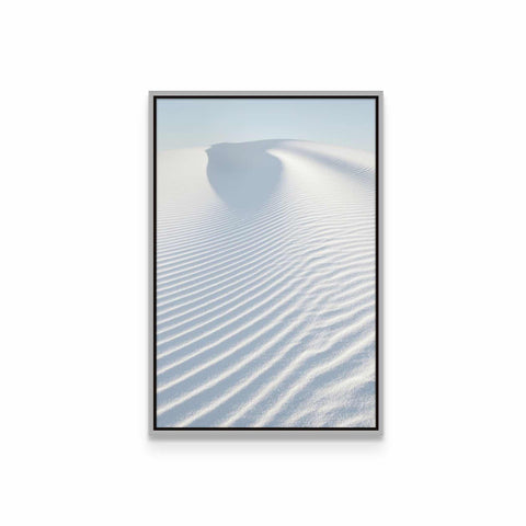 a framed photograph of a white sand dune