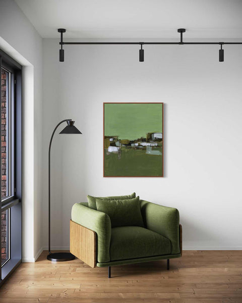a living room with a green chair and a lamp