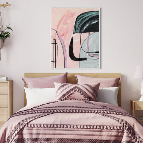 a bed with a pink comforter and a painting on the wall