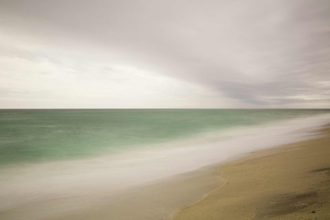 a beach with a wave coming in to shore