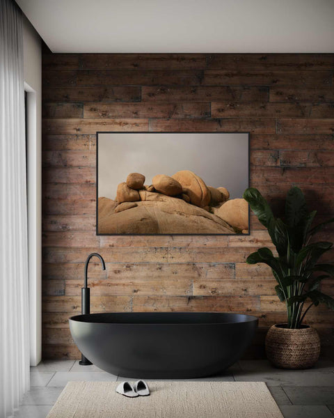 a bathroom with a black bathtub and a painting on the wall