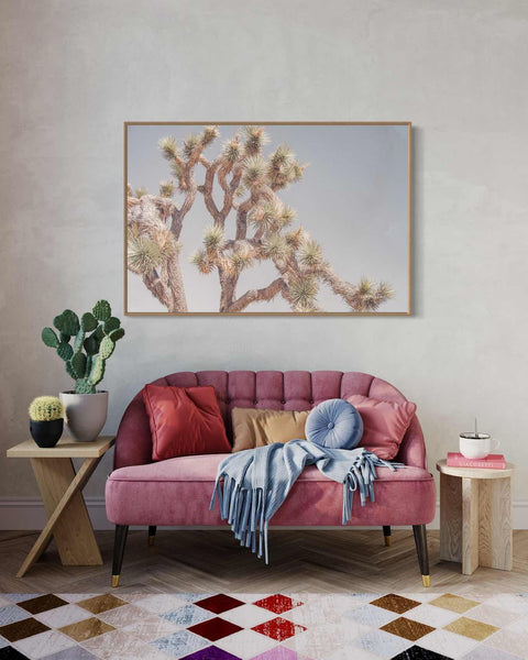 a living room with a pink couch and a painting on the wall