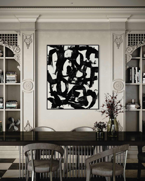 a black and white painting on a wall above a dining room table