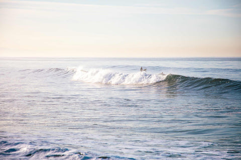 a person riding a wave on top of a surfboard