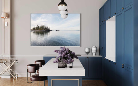 a kitchen with blue cabinets and a large picture on the wall