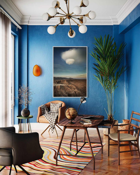 a living room with blue walls and a painting on the wall