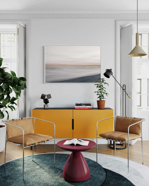 a living room with a yellow cabinet and chairs