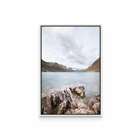 a picture of a lake with rocks in the foreground